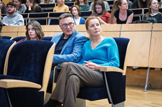 Zbliżenie na słuchaczy wykładu siedzących w rzędach.