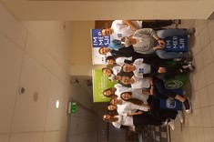 Zdjęcie przedstawia grupę osób należących do koła naukowego IMMERSJA, znajdują się wewnątrz budynku na tle rollupów. 