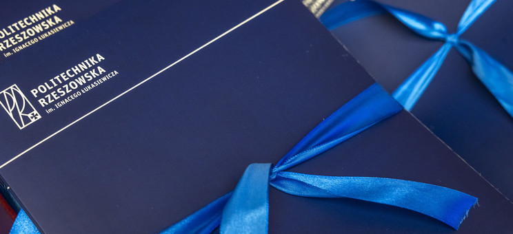 Zdjęcie przedstawia granatowe eleganckie okładki z białym napisem Politechnika Rzeszowska. 