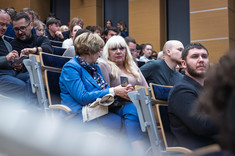 Zbliżenie na uczestników wykładu siedzących w rzędach.