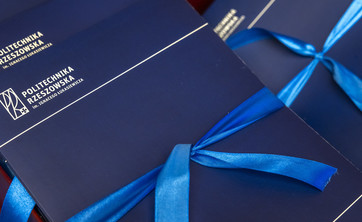 Zdjęcie przedstawia granatowe eleganckie okładki z białym napisem Politechnika Rzeszowska.