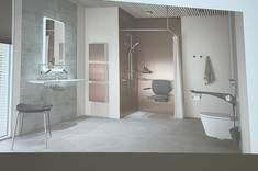 Na zdjęciu ekran z wyświetloną prezentacją. Na slajdzie widoczne wnętrze łazienki utrzymane w jasnych kolorach.