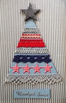 Kartka świąteczna. Na srebrnym tle wycięty prosty, trójkątny niebieski kształt choinki. Na trójkącie umieszczone równoległe poziome pasy z szarej, granatowej i czerwonej koronki. Na czubku choinki szara gwiazda. Pod spodem napis: Wesołych Świat.