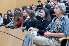 Zbliżenie na słuchaczy wykładu siedzących w rzędach.