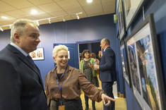 Kobieta w brązowej bluzce i mężczyzna w garniturze rozmawiają o jednym ze zdjęć, fot. B.Motyka 