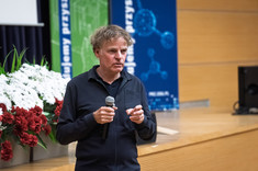 Mężczyzna ubrany na czarno podczas prowadzenia wykładu.