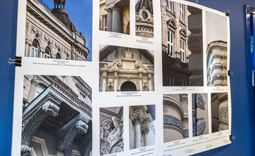 Na ciemno granatowej ścianie zawieszona plansza z kilkoma kolorowymi fotografiami. Na każdej z fotografii ujęcia rzeźbionych detali ścian.