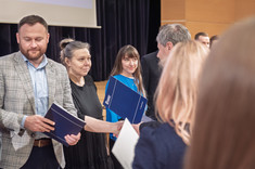 Na zdjęciu kilkanaście oficjalnie ubranych osób podczas wręczania nagród.